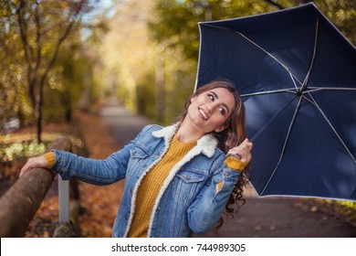 A Young Beautiful Woman Is Walking Along The Autumn Park With An Umberella In Her Hands. Autumn Portrait Of Young Happy Woman. Autumn. Rain.