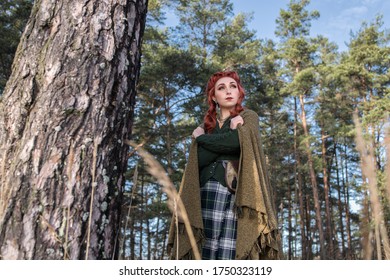 Young Beautiful Woman Walking In The Forest And Wearing Green Kilt, Scottish Style, Ginger Hair