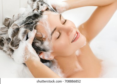 Young And Beautiful Woman Is Washing Her Hair With Shampoo