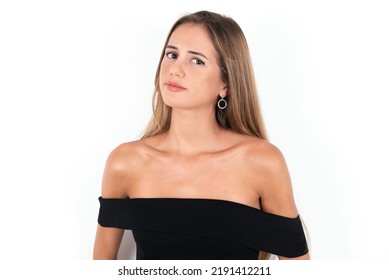 Young Beautiful Woman Wearing Black Tank Top Over White Background With Snobbish Expression Curving Lips And Raising Eyebrows, Looking With Doubtful And Skeptical Expression, Suspect And Doubt.