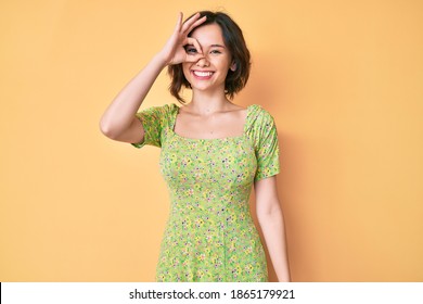 Young beautiful woman wearing casual clothes smiling happy doing ok sign with hand on eye looking through fingers 