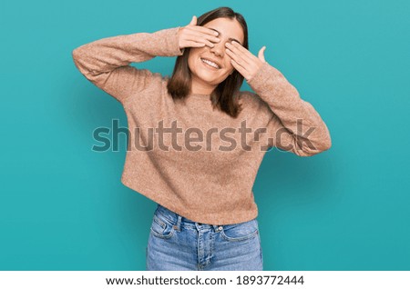 Young beautiful woman wearing casual clothes covering eyes with hands smiling cheerful and funny. blind concept. 