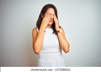 Young beautiful woman wearing dress standing over white isolated background rubbing eyes for fatigue and headache, sleepy and tired expression. Vision problem
