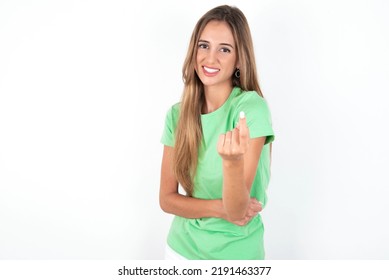 Young Beautiful Woman Wearing Green T-shirt Over White Background Beckoning Come Here Gesture With Hand Inviting Welcoming Happy And Smiling