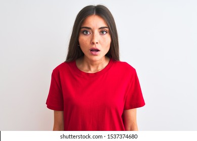 Young beautiful woman wearing red casual t-shirt standing over isolated white background afraid and shocked with surprise expression, fear and excited face.