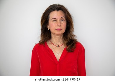 Young Beautiful Woman Wearing Red T-shirt Standing Over Isolated White Background Winking Looking At Camera With Serious Expression.