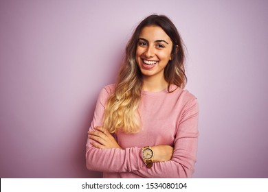 Young beautiful woman wearing a sweater over pink isolated background happy face smiling with crossed arms looking at the camera. Positive person.