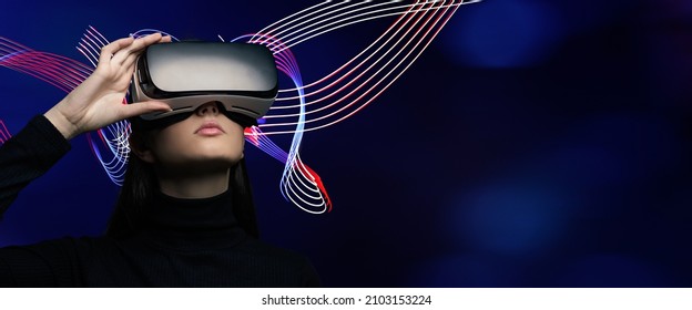 Young beautiful woman wearing a VR headset and experiencing a virtual reality simulation, metaverse and cyberspace concept - Powered by Shutterstock