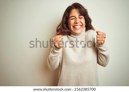 Young beautiful woman wearing winter sweater standing over white isolated background excited for success with arms raised and eyes closed celebrating victory smiling. Winner concept.