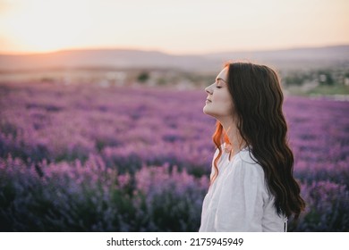 Young beautiful woman in white dress enjoying flower fragrance on lavender field. - Powered by Shutterstock