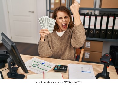 Young Beautiful Woman Working At Small Business Ecommerce Holding Money Annoyed And Frustrated Shouting With Anger, Yelling Crazy With Anger And Hand Raised 