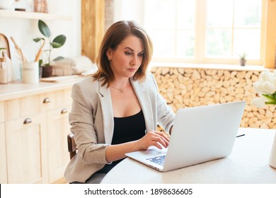 Young Beautiful Woman Works For A Computer From A Home With A Laptop In A Kitchen As A Freelancer. Not Happy With The Result