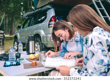 Image, Stock Photo Young women looking road map with 4×4 on background