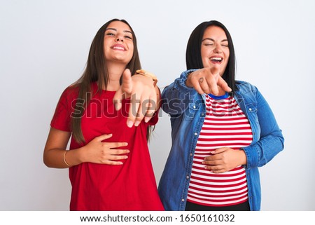 Young beautiful women wearing casual clothes standing over isolated white background laughing at you, pointing finger to the camera with hand over body, shame expression
