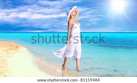 Young beautiful women in the white on the sunny tropical beach