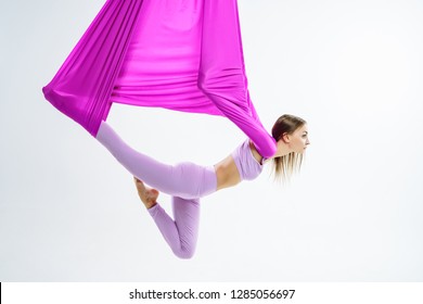 Young beautiful yogi woman doing aerial yoga practice in purple hammock - Powered by Shutterstock