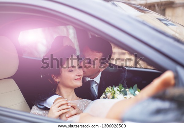 young beautifull couple kissing in the car after\
registering a marriage