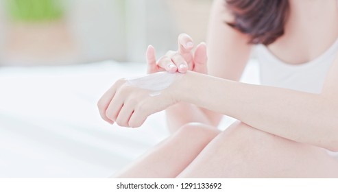 Young beauty asian woman applying hand cream at home