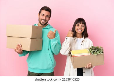 young beauty couple moving in new home among boxes isolated on pink background giving a thumbs up gesture with both hands and smiling - Powered by Shutterstock