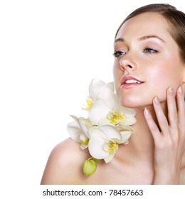 Young beauty with fresh white orchids. Space for text.