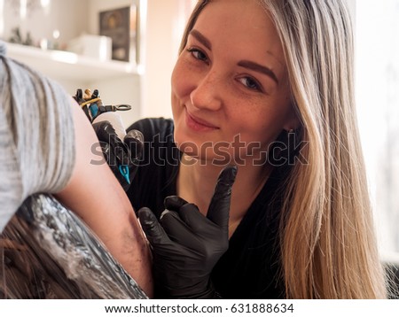 young beauty girl makes a tattoo on a hand man's closeup. The girl is smiling. Everything is good concept