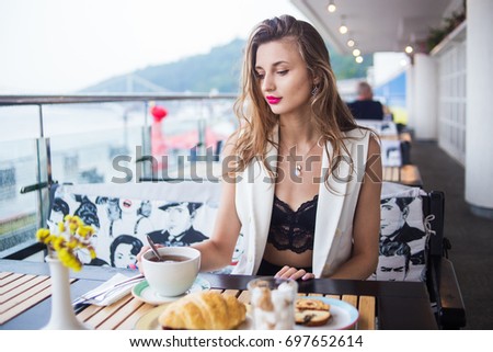 Young beauty girl posing in cafe near with cup of tea