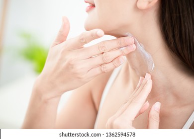 young beauty woman applying cream or sunscreen on her neck