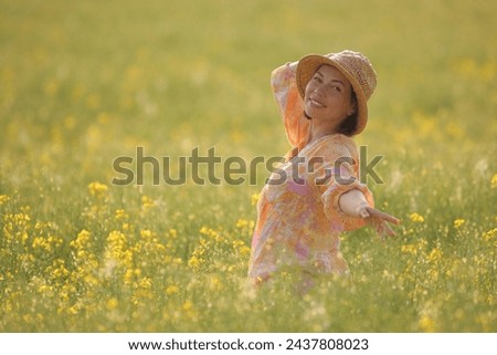 young beauty woman in a field with rapeseed