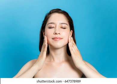 Young Beauty Woman Massaging Her Face. Facial Massage Concept.