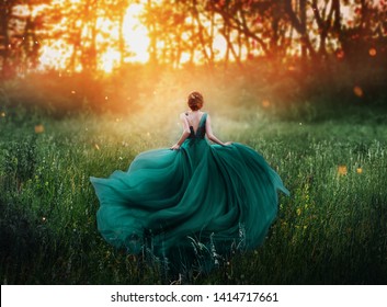 young beauty woman queen red hair runs dark mysterious forest lady long elegant royal emerald dress flying train spring tree grass sunset art photo bare open back no face turned away clothes costume