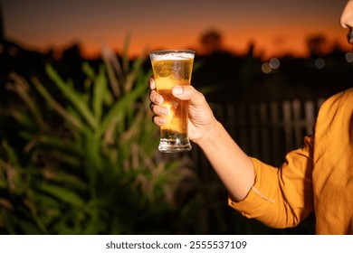 Young beer man holding a glass of beer in his hand, drinking craft beer to test the taste and color of beer in a craft brewery. - Powered by Shutterstock