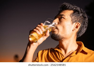 Young beer man holding a glass of beer in his hand, drinking craft beer to test the taste and color of beer in a craft brewery. - Powered by Shutterstock