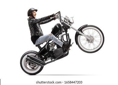 Young biker riding a custom motorbike on one wheel isolated on white background