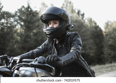 Young Biker Woman Riding Chopper Motorbike On Forest Road