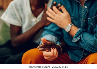 Young biracial couple with problems trying to solve conflict at couple therapy session with a counseling adviser. Focus on a diverse spouses holding hands while solving problem with a psychologist. - Powered by Shutterstock