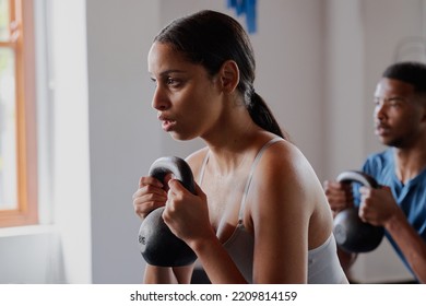 Young Biracial Woman And Black Man Doing Kettlebell Squats At The Gym