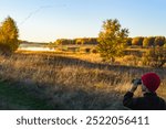 Young bird watcher looking at a flock of birds preparing to migrate to Southern countries on Autumn day