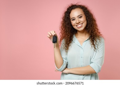 Young Black African American Fun Smiling Satisfied Happy Curly Female Driver Woman 20s Wearing Casual Blue Shirt Holding Car Key Looking Camera Isolated On Pastel Pink Color Background Studio Portrait