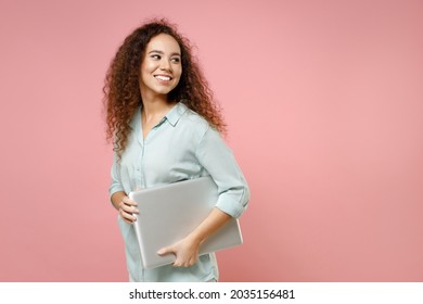 Young Black African American Smiling Confident Fun Freelancer Curly Woman In Blue Shirt Hold Going With Closed Laptop Pc Computer Look Aside Isolated On Pastel Pink Color Background Studio Portrait