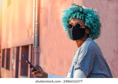 young black african american woman with mobile phone and mask on the street - Powered by Shutterstock