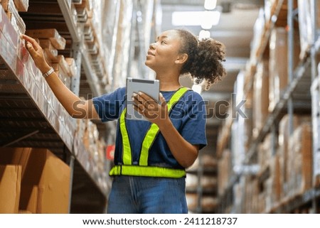 Young black African American woman holding a tablet checks inventory and checks orders from customers to deliver documents to customers in a warehouse wholesale store.