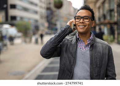 Young Black African Asian Mixed Man In City Talking On Cell Phone