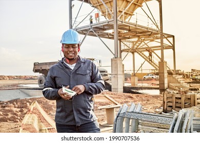 A Young Black African Coal Mine Worker Wearing Coveralls And Hard Hat Is Smiling After A Long Day Of Work On Site At The Coal Mine