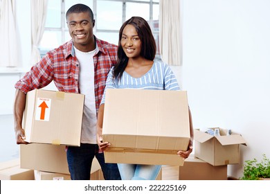 Young Black African Couple Moving Boxes Into New Home Together Making A Successful Life