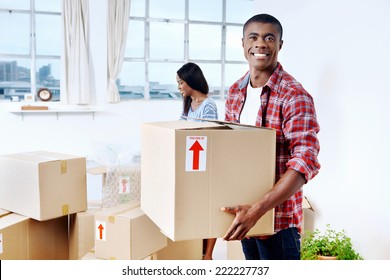 Young Black African Couple Moving Boxes Into New Home Together Making A Successful Life