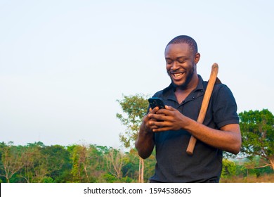 Young Black African Farmer Checking Interesting Content On Smart Phone