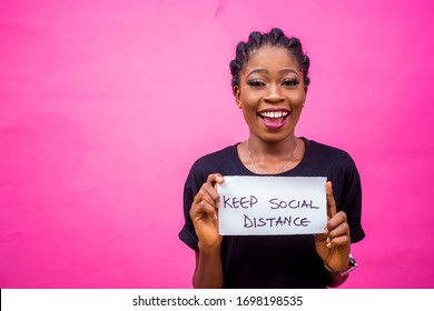 Young Black African Girl Carrying A Placard Enlighing People To Keep Social Distancing