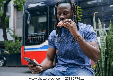 Similar – Foto Bild Junger afrikanischer Mann isst in einem Imbisswagen im Freien im Stadtpark