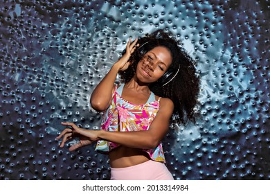 Young Black Afro Woman With Headphones Dancing Inspired By The Beat Of The Music