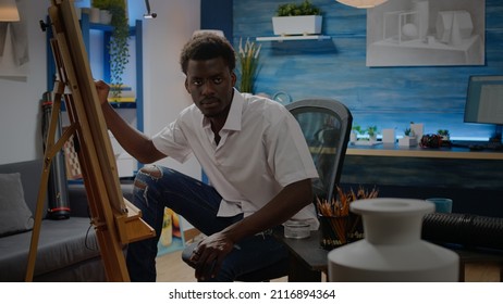 Young Black Artist Drawing And Getting Inspiration From Vase Design On Table. African American Person Sitting In Workshop Studio Creating Fine Art Masterpiece As Professional Hobby